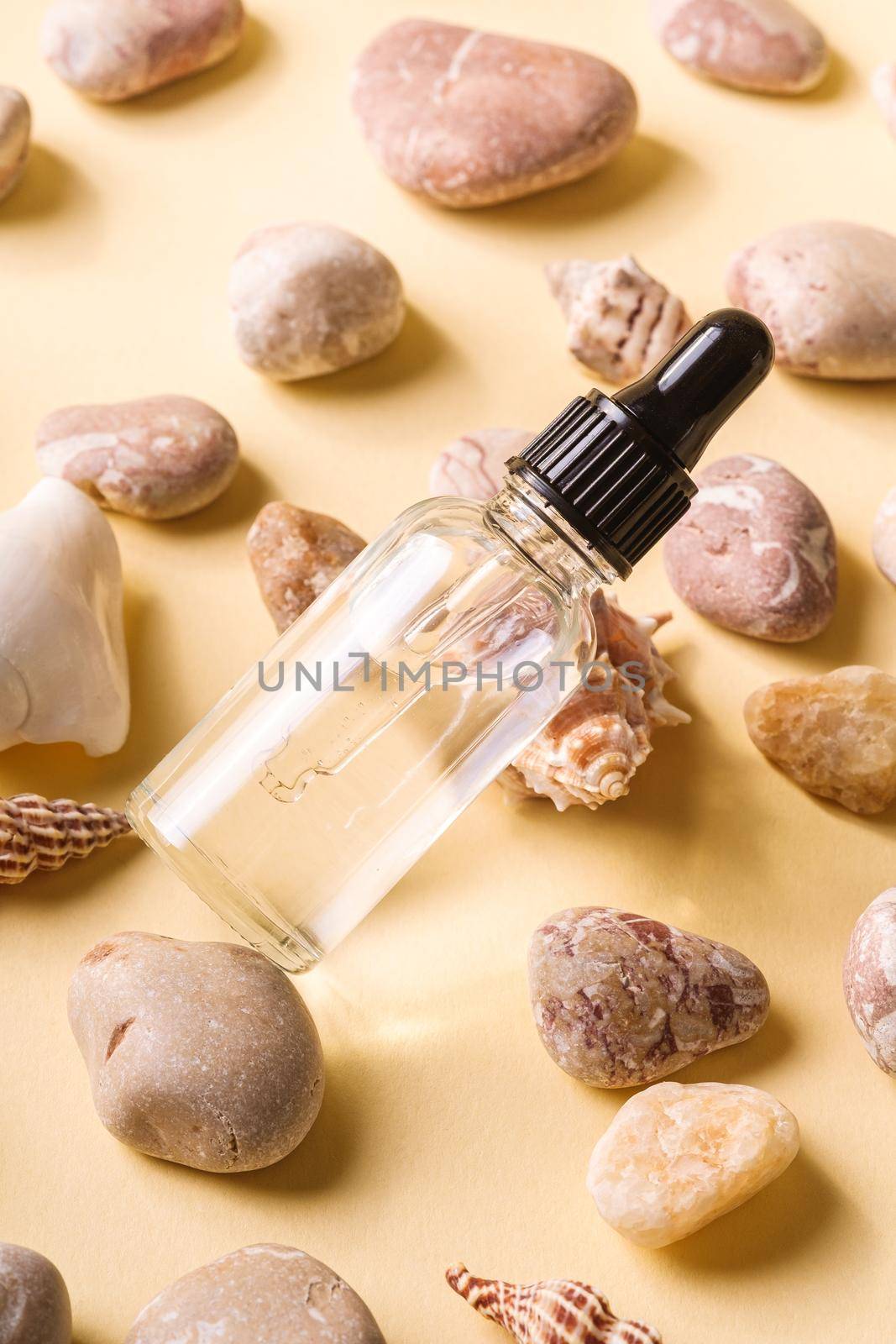 Skin care essence oil dropper in glass bottle on beige background
