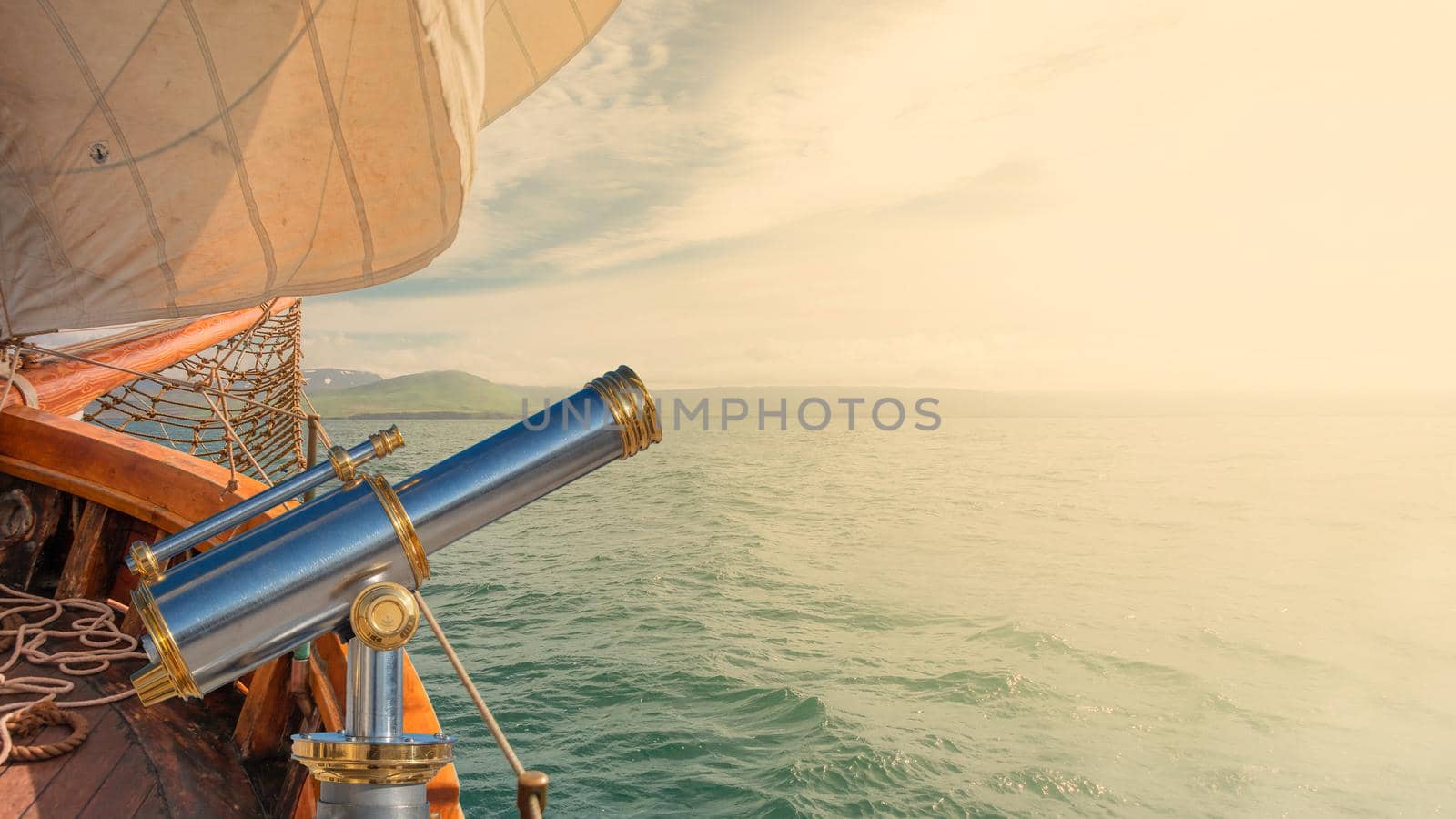 Banner with an old sailing boat towards dreams and adventures, with copy space for text and an ancient telescope. Concept travel, freedom and adventure, nomadic lifestyle.