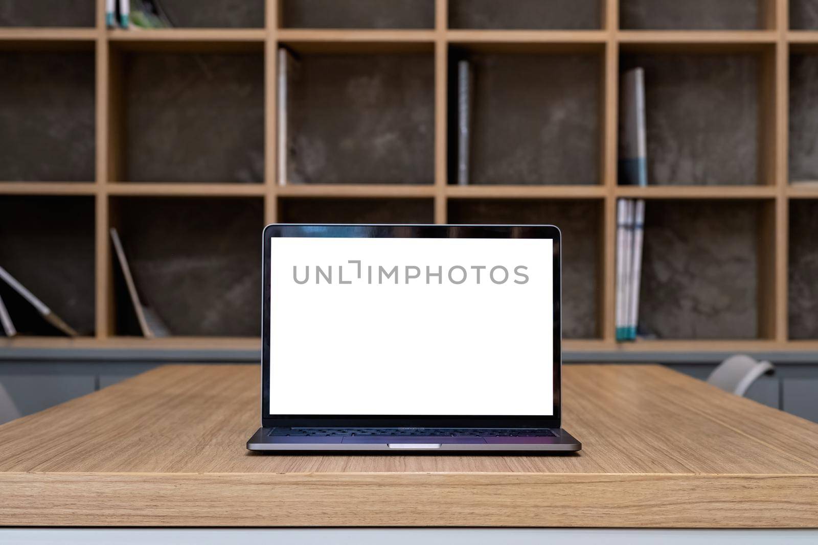 Laptop with blank screen on table in library room by nateemee