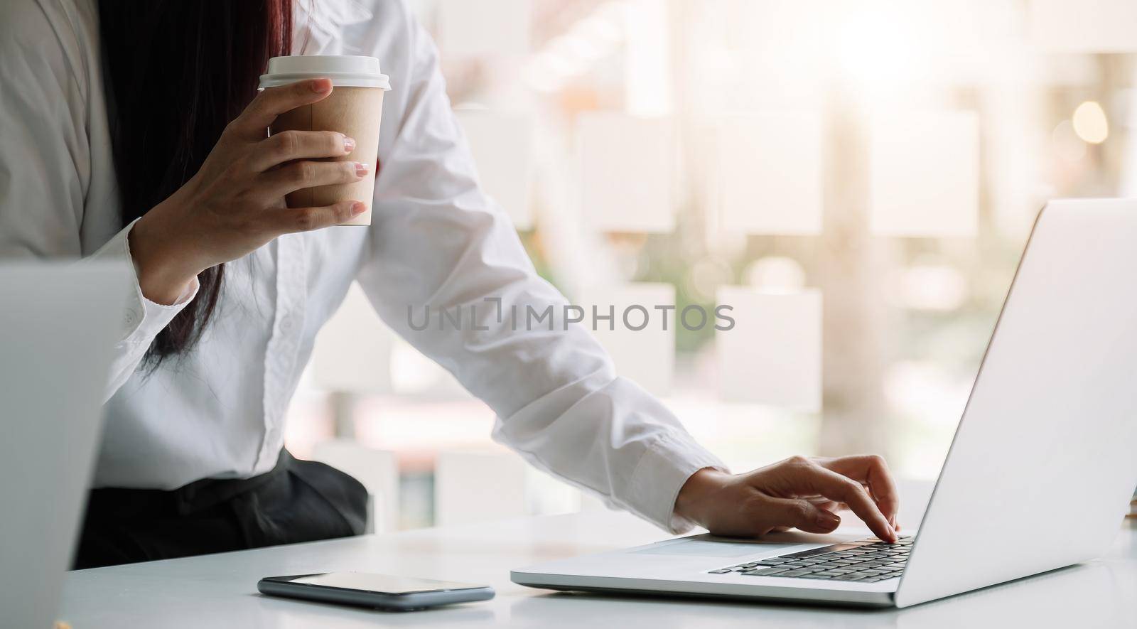 Businesswoman working on computer at table in office, by nateemee