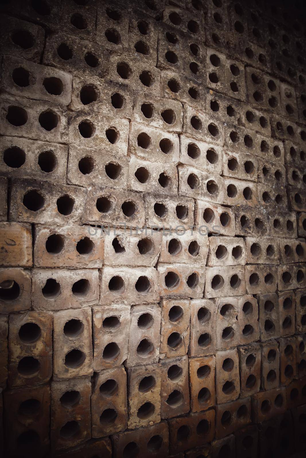 Detail of old mud brick wall with holes, construction