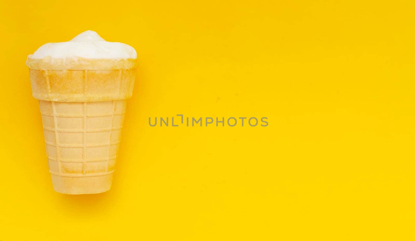 Waffle cup of cream ice cream on pastel yellow background, copyspace.Traditional russian ice-cream.