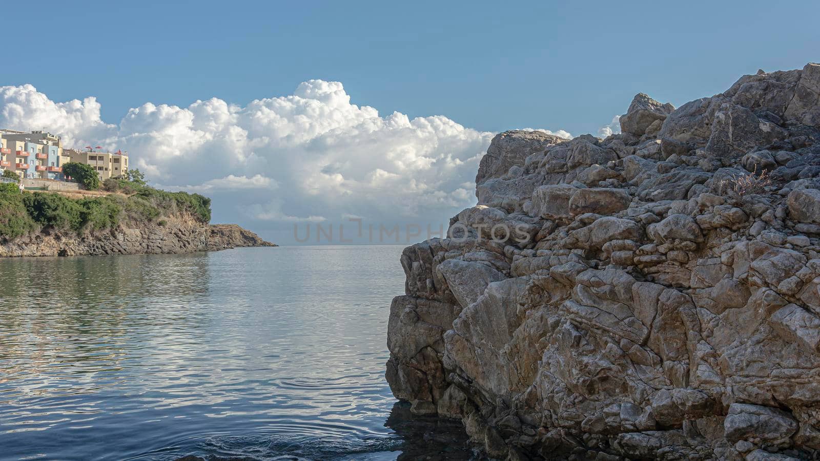 Seascape. Apartments on the rocky seashore (Greece, Crete). Stock photo. by Grommik