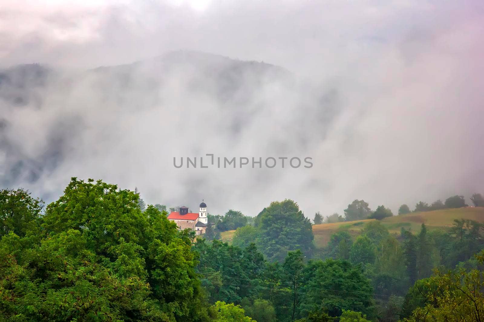 beauty mountain landscape with alone building and mist over the mountain