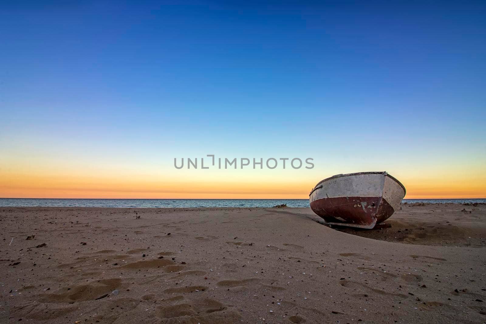 lonely old boat on the beach at sunset. Horizontal view