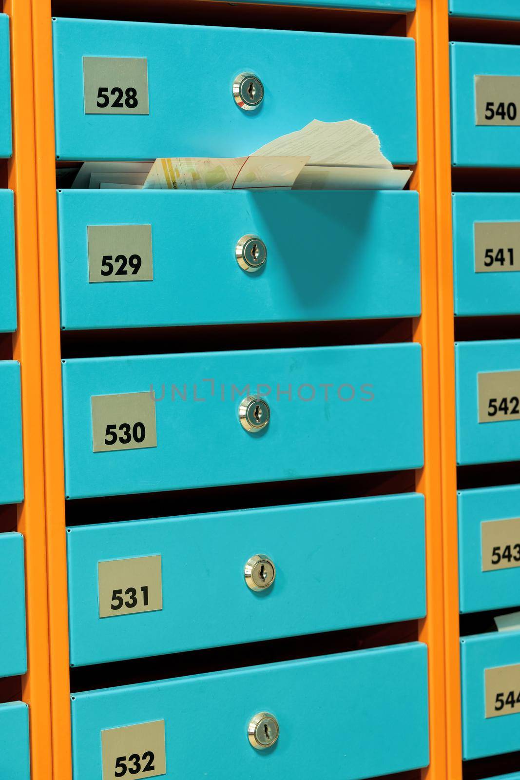 A group of blue metallic mailboxes with round locks