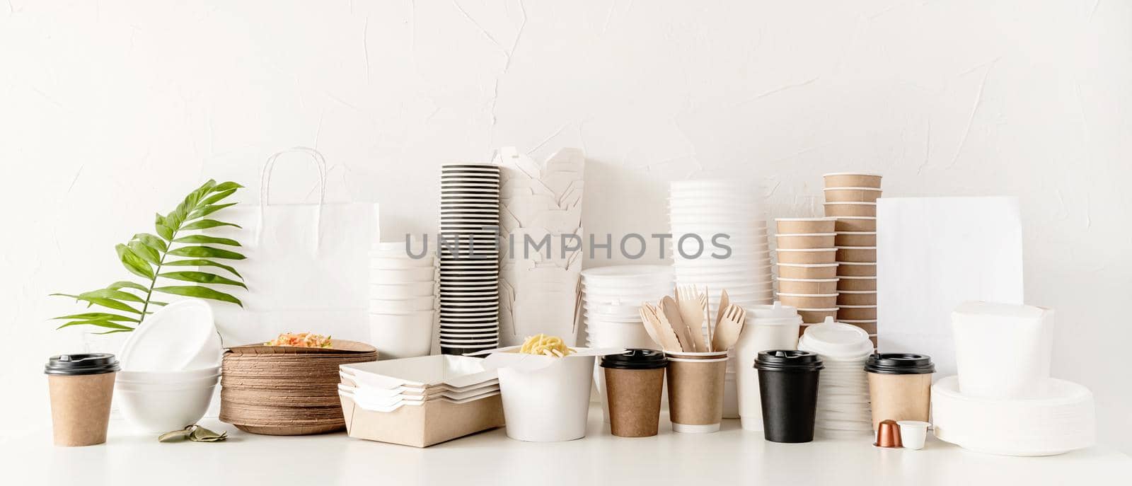 Eco friendly disposable tableware and eating utensils on table by Desperada