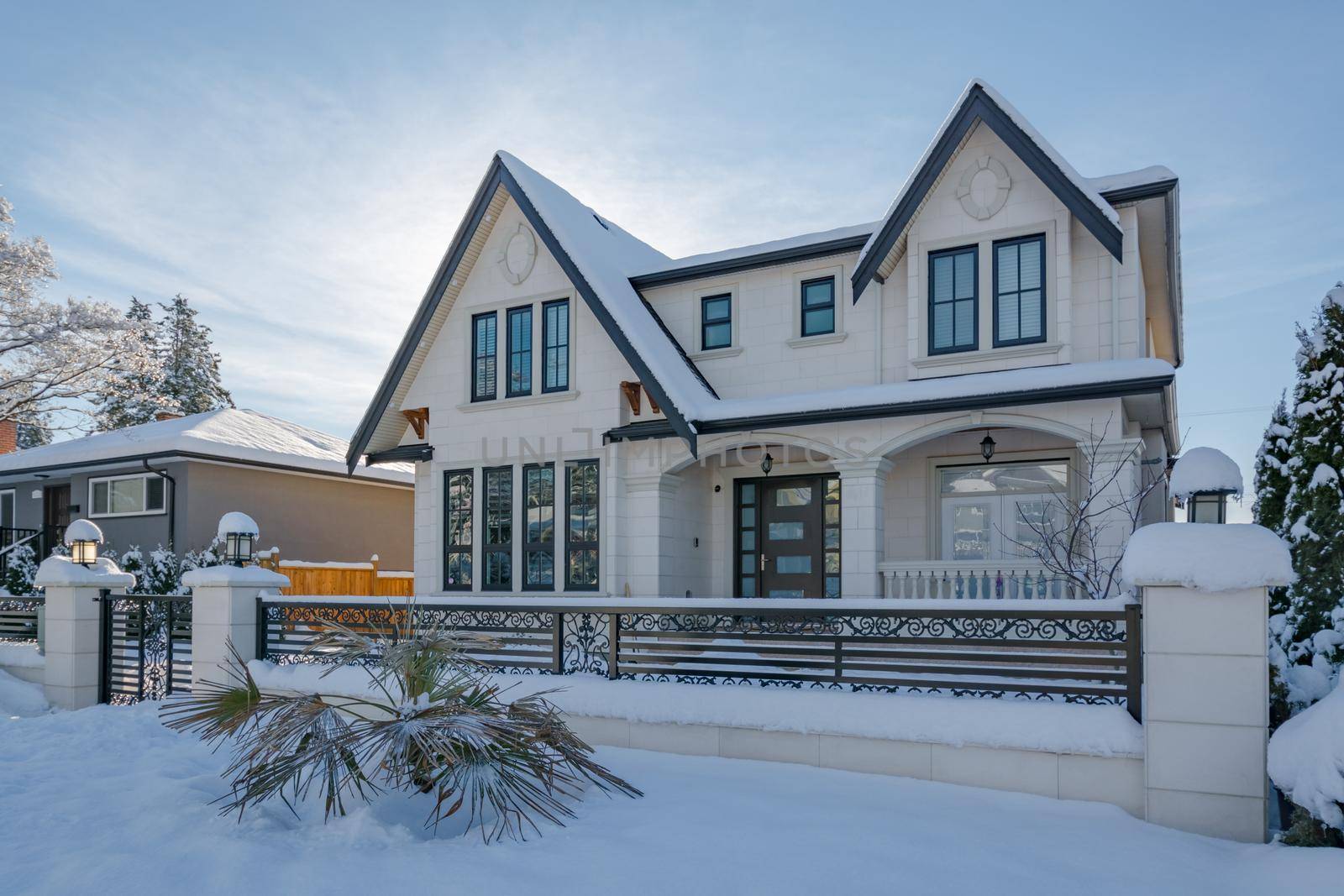 Luxurious residential house with front yard in snow. North American family house on winter sunny day