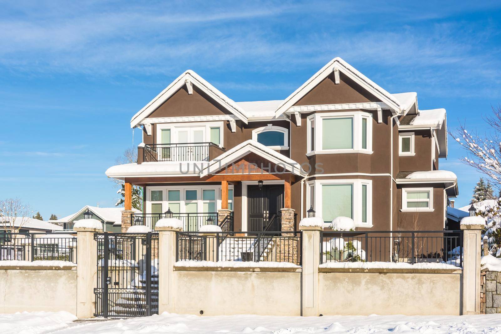 Luxury residential house with front yard in snow. North American family house on winter sunny day
