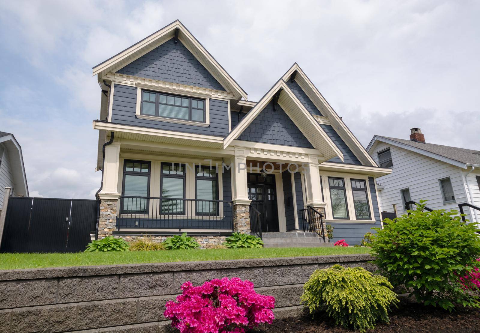 Luxury residential house with front yard over land terraces. Big family house with nice landscaping in front