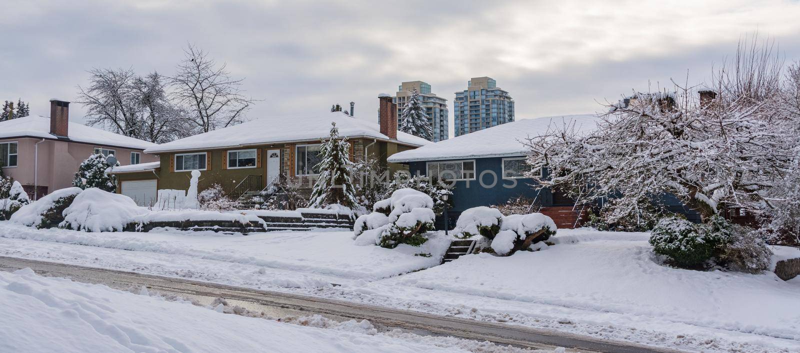 Street of residential houses in suburban. Family houses in snow on winter season by Imagenet