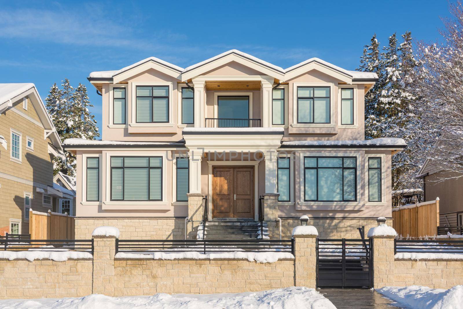 Luxury residential house with front yard in snow. North American family house on winter sunny day