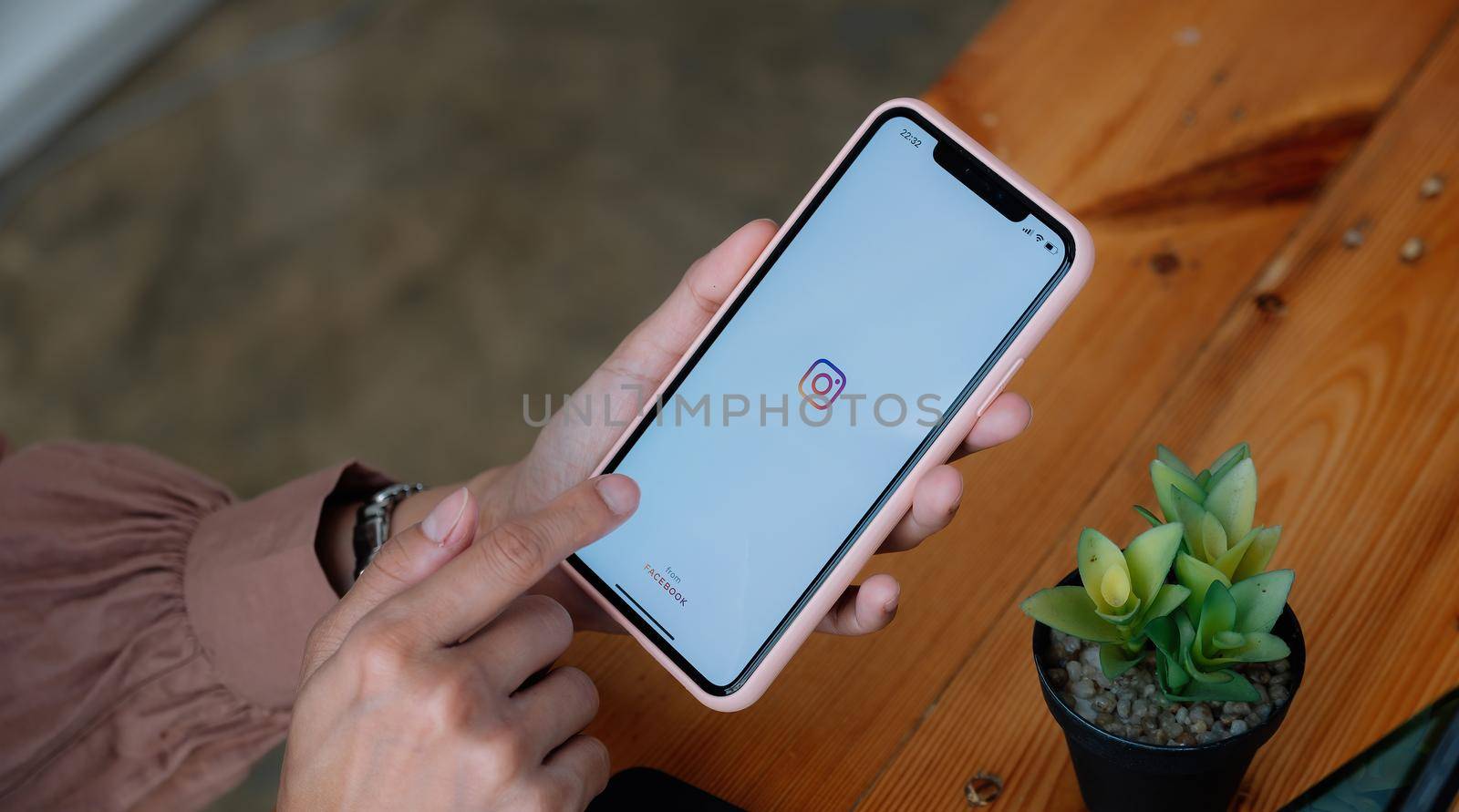 CHIANG MAI, THAILAND - MAR 21 2021 : Woman hand holding iphone with logo of instagram application. Instagram is largest and most popular photograph social networking.