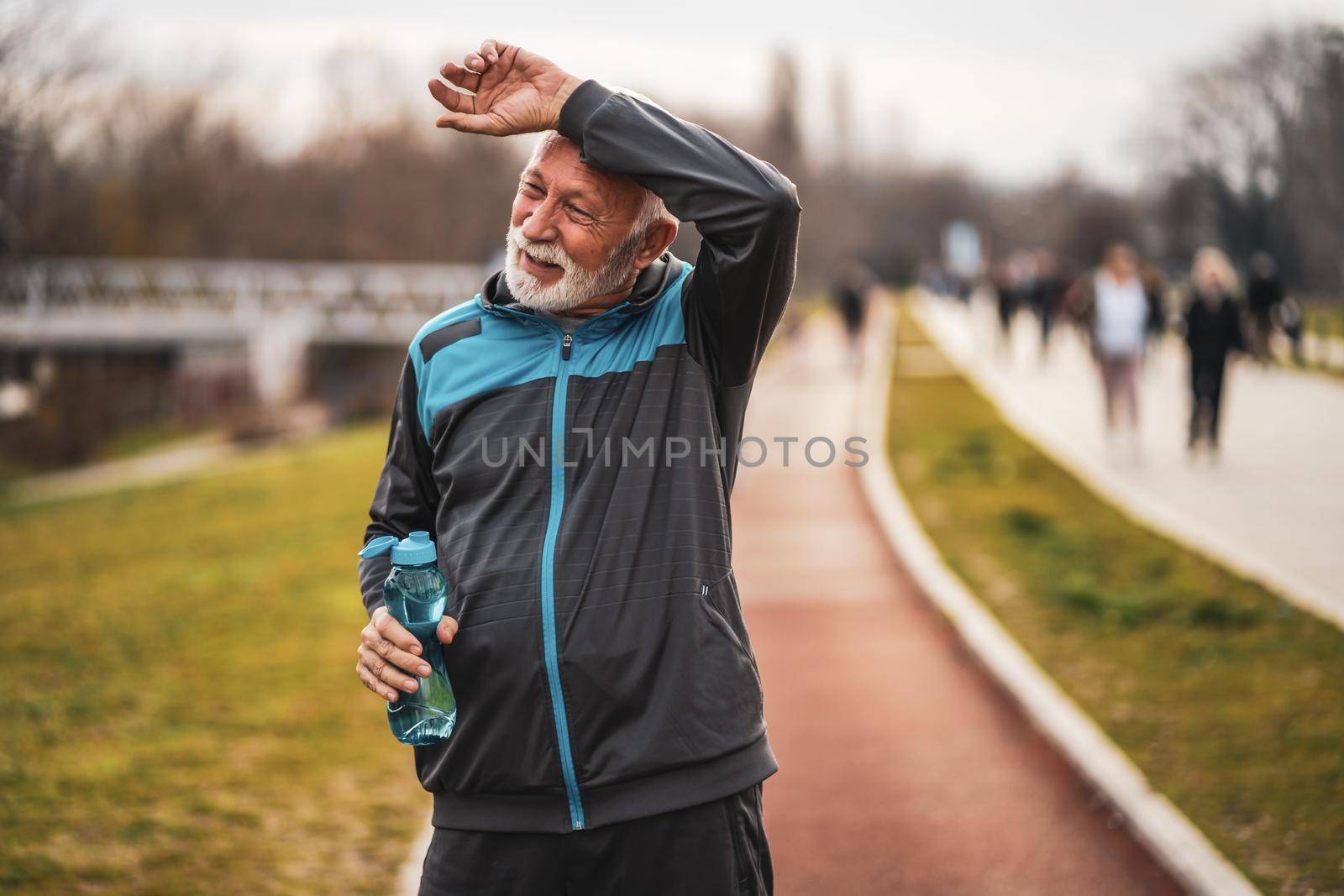 Active senior man is tired after exercising. Healthy retirement lifestyle.