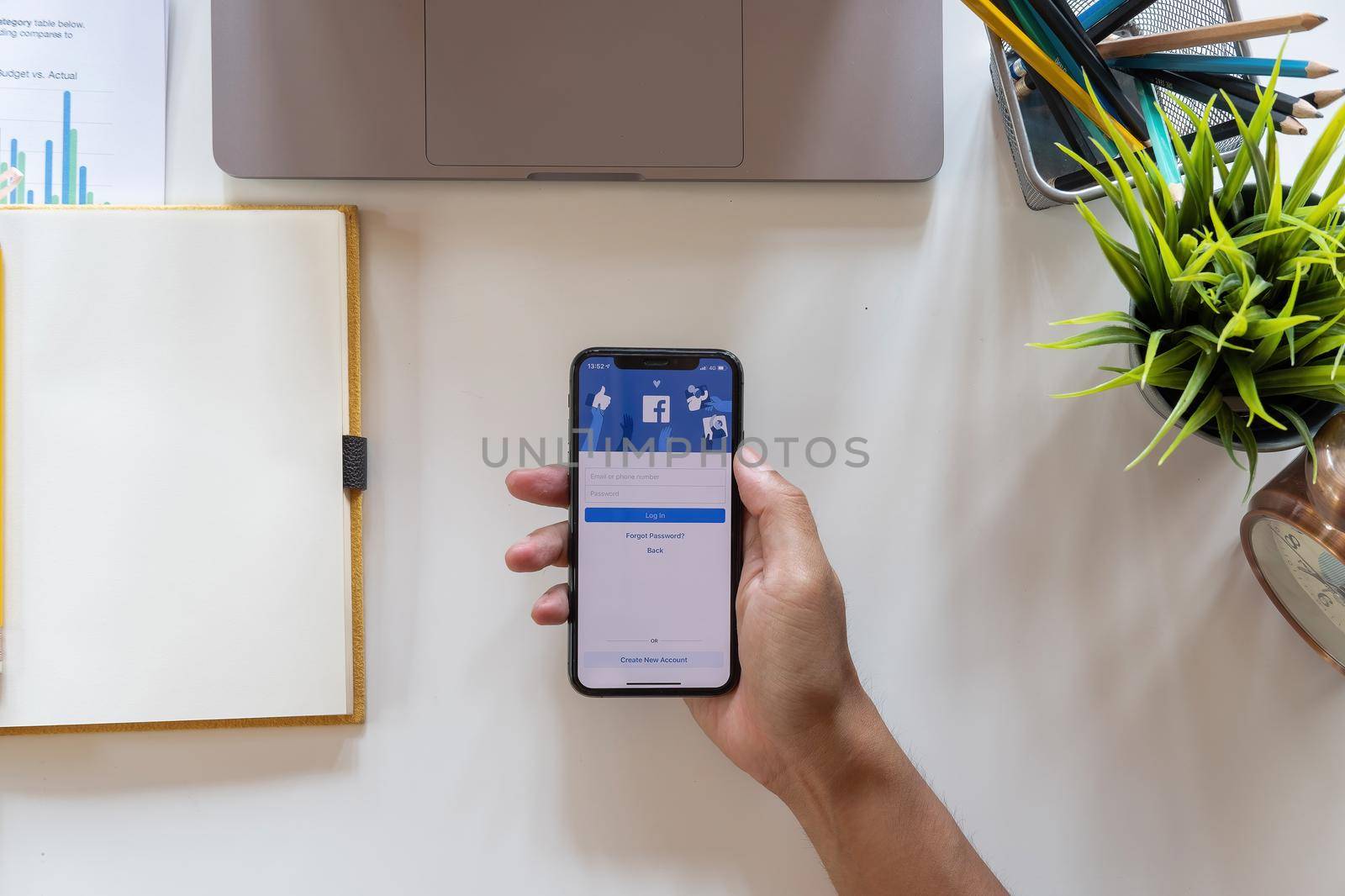 CHIANG MAI, THAILAND - APR 15, 2021 : Facebook social media app on log-in, sign-up registration page on mobile app screen on iPhone X in person's hand working on e-commerce shopping business