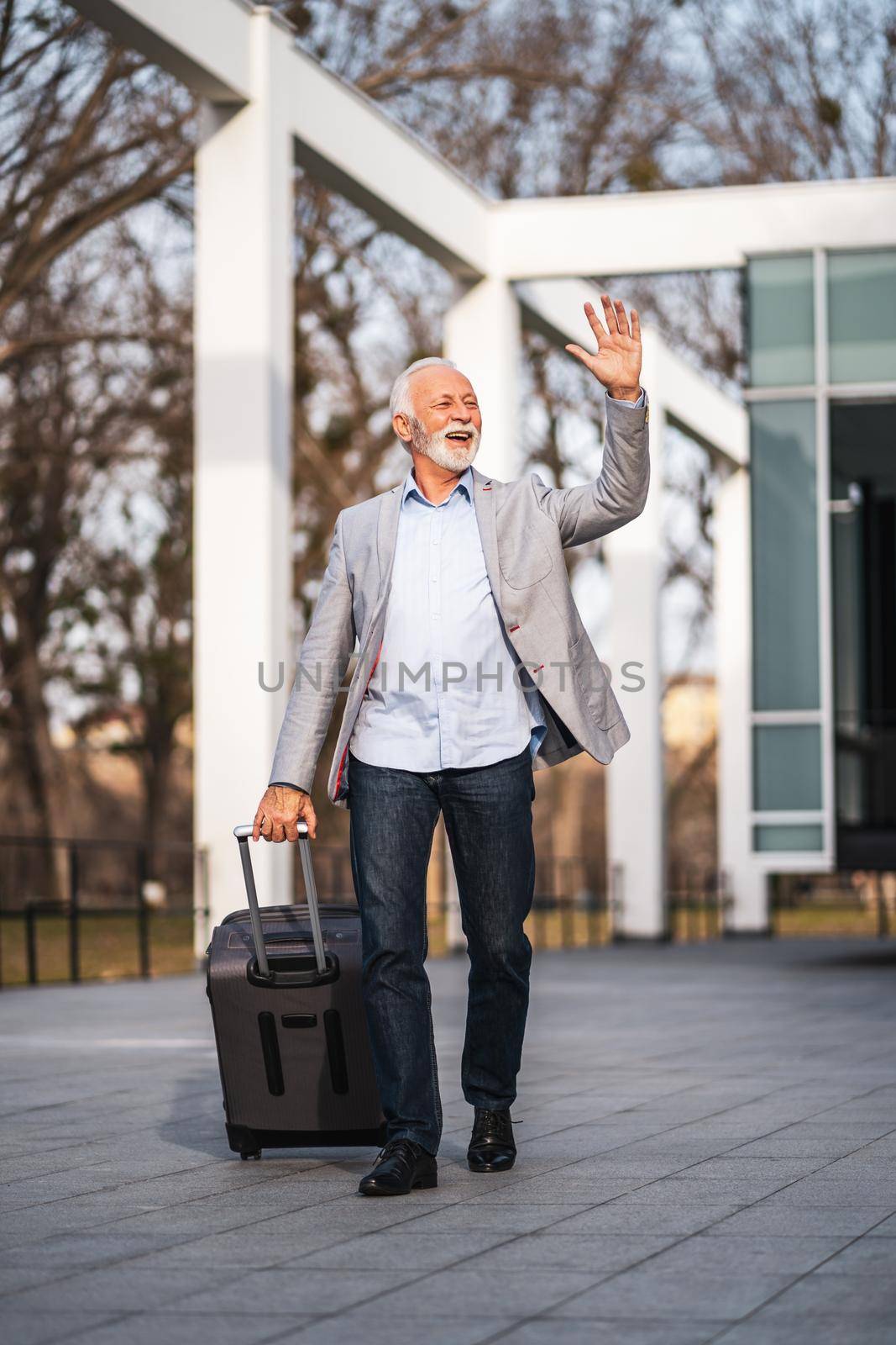 Happy senior businessman is arriving from business trip.