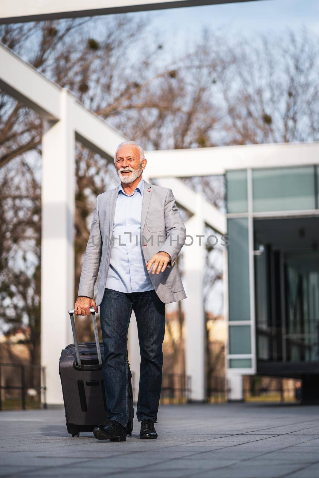 Happy senior businessman is arriving from business trip.