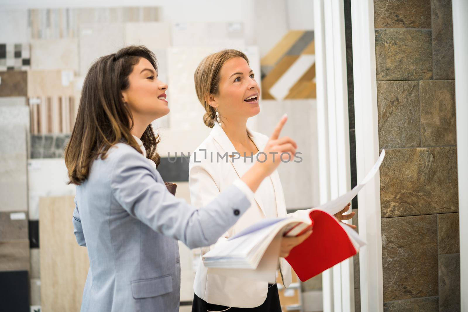 Businesswoman owning small business store. She is talking with a customer who is choosing the goods.