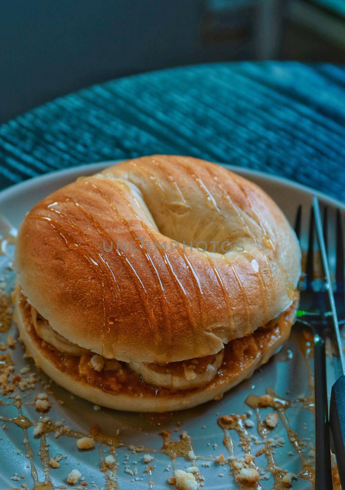 Closeup plain bagel with banana and peanut butter