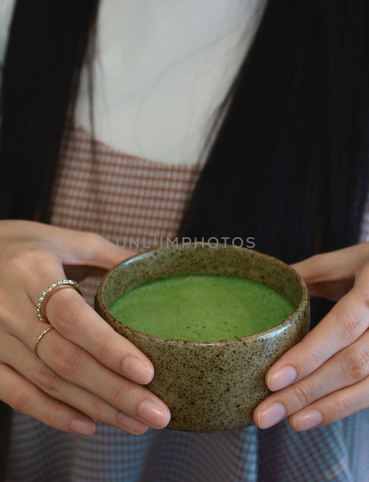 closeup hot matcha in female hand