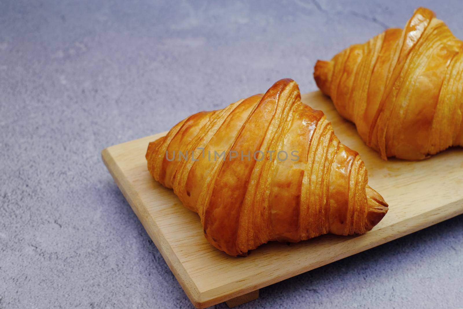 Closeup butter classic croissant on wood plate