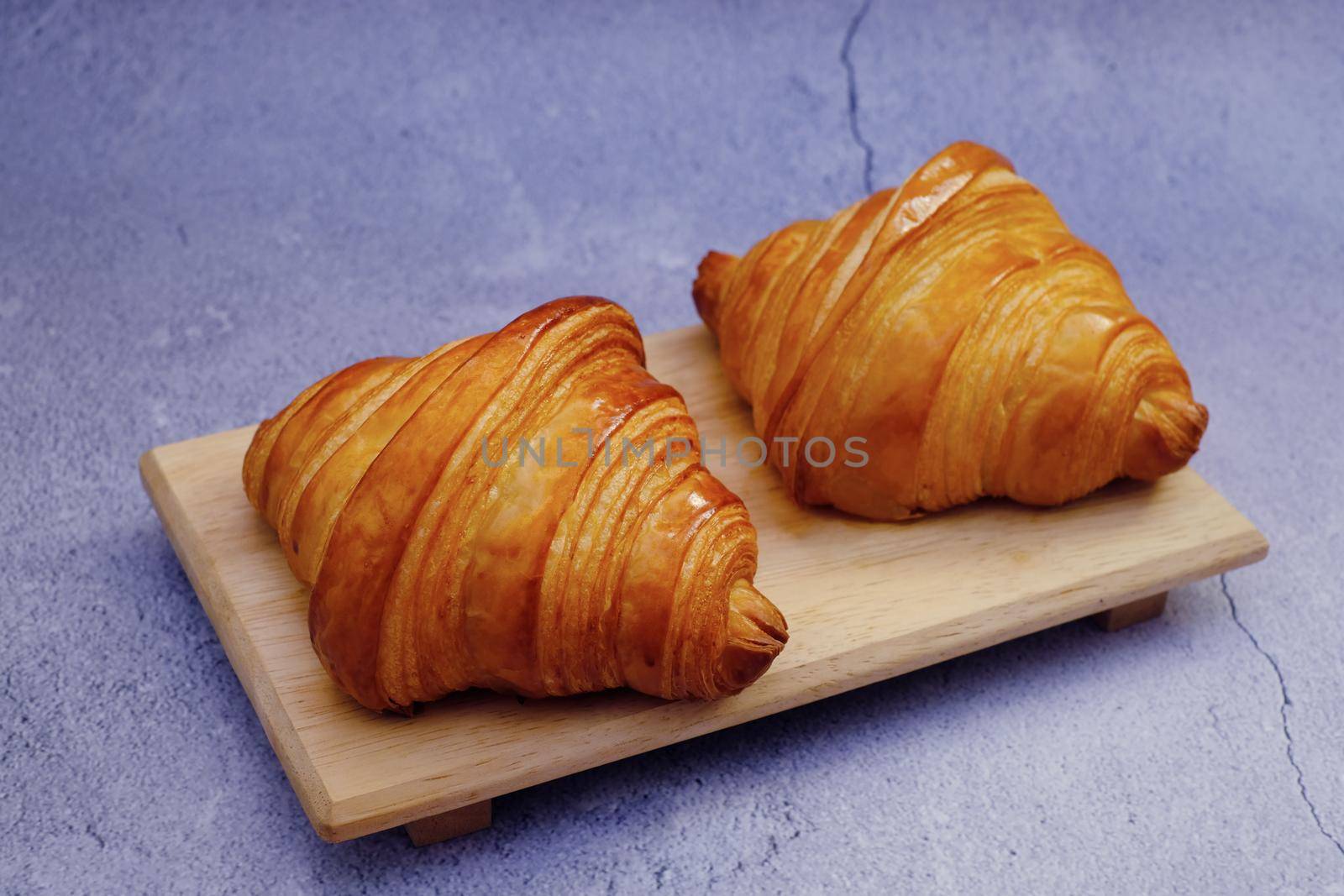 Closeup butter classic croissant on wood plate