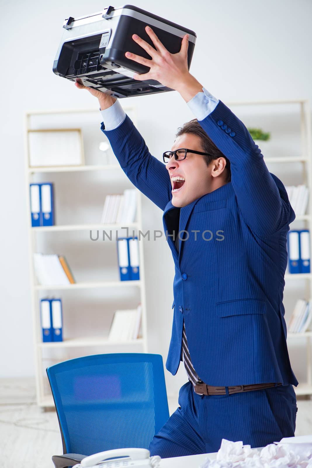 Businessman angry at copying machine jamming papers