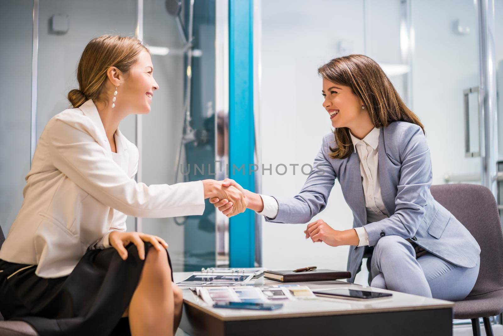 Businesswoman owning small business bath store. She is handshaking with a satisfied customer.