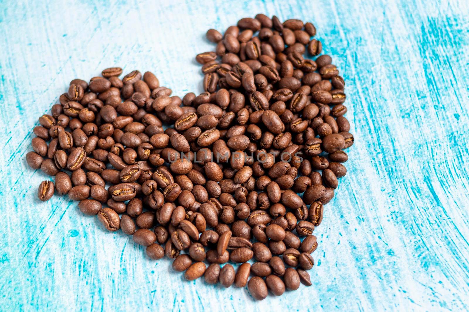 Heart shaped coffee grains on aquamarine background by eagg13