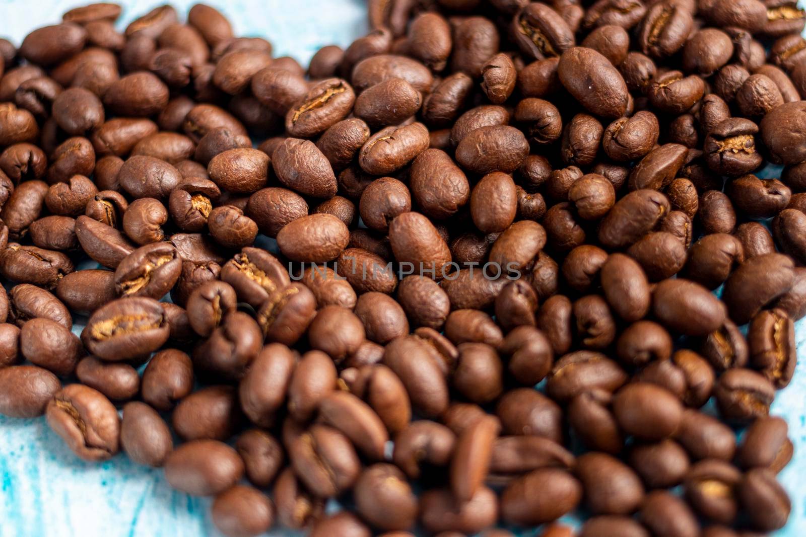 Heart shaped coffee grains on aquamarine background