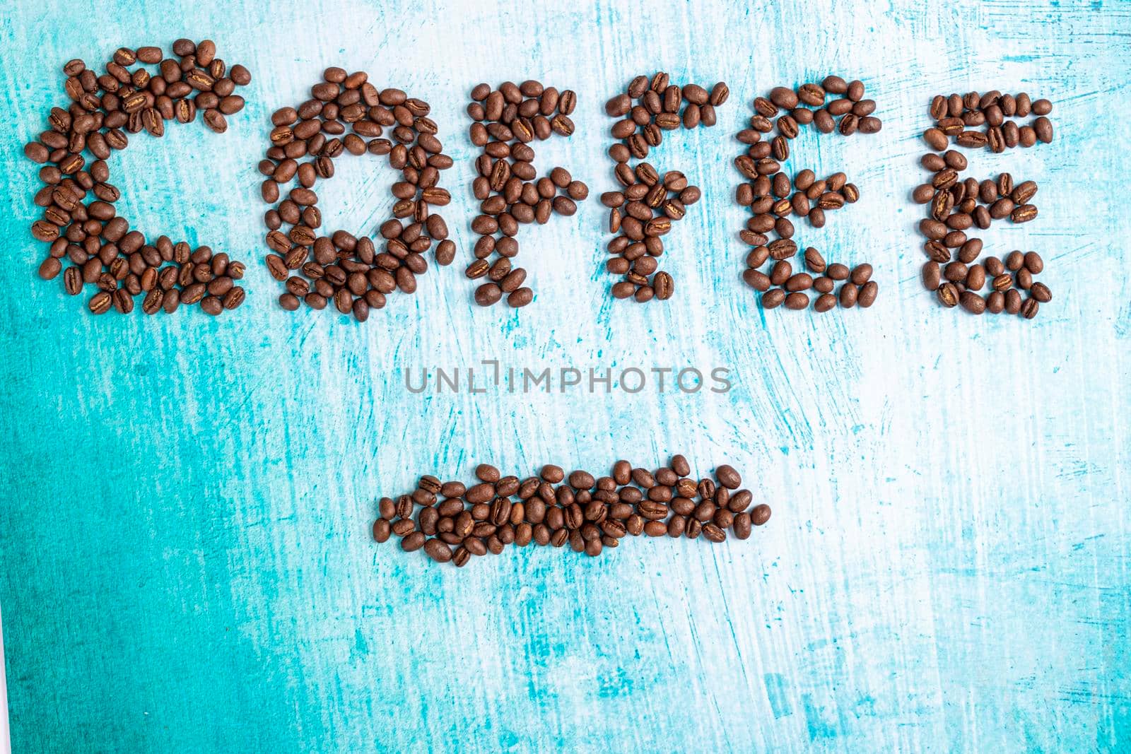 Roasted coffee grains on aquamarine background