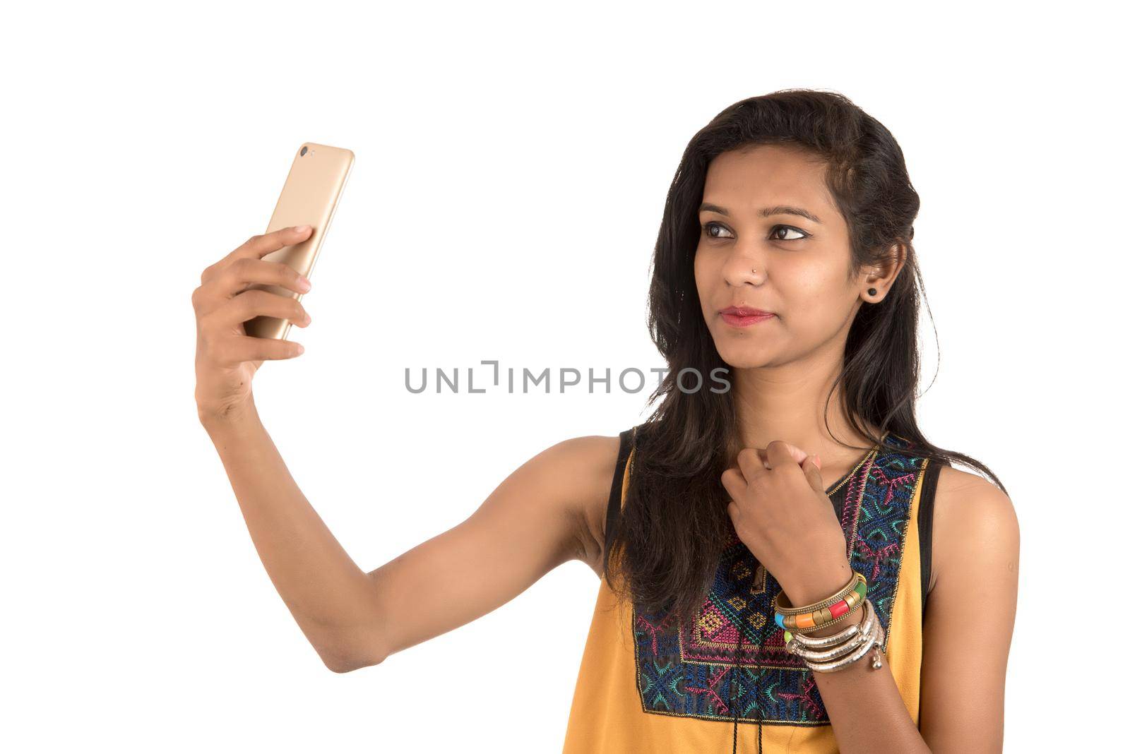 Portrait of a happy young girl using mobile phone isolated over white background