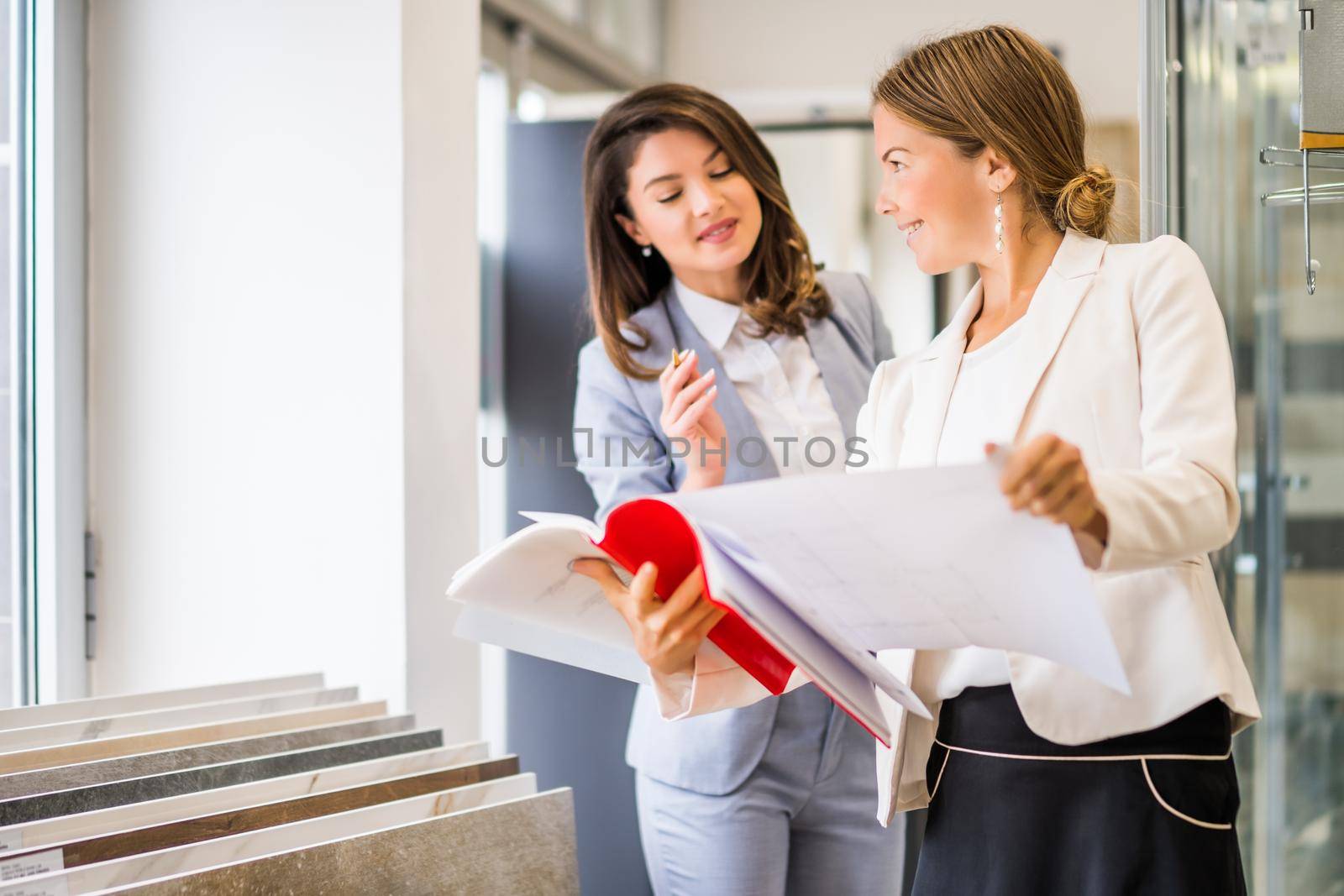 Businesswoman owning small business bath store. She is talking with a customer who is choosing the goods.