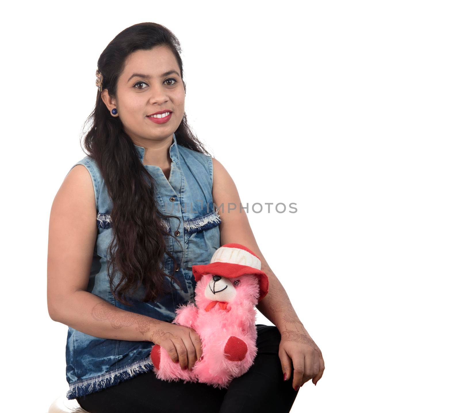 Beautiful young girl holding and playing with a teddy bear toy on a white background. by DipakShelare