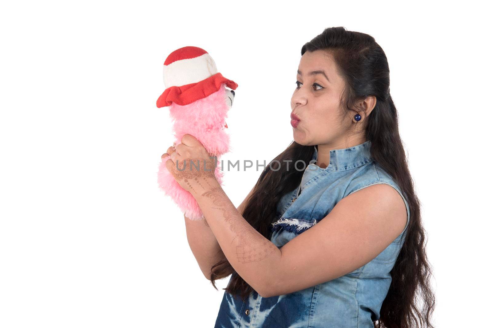 Beautiful young girl holding and playing with a teddy bear toy on a white background. by DipakShelare