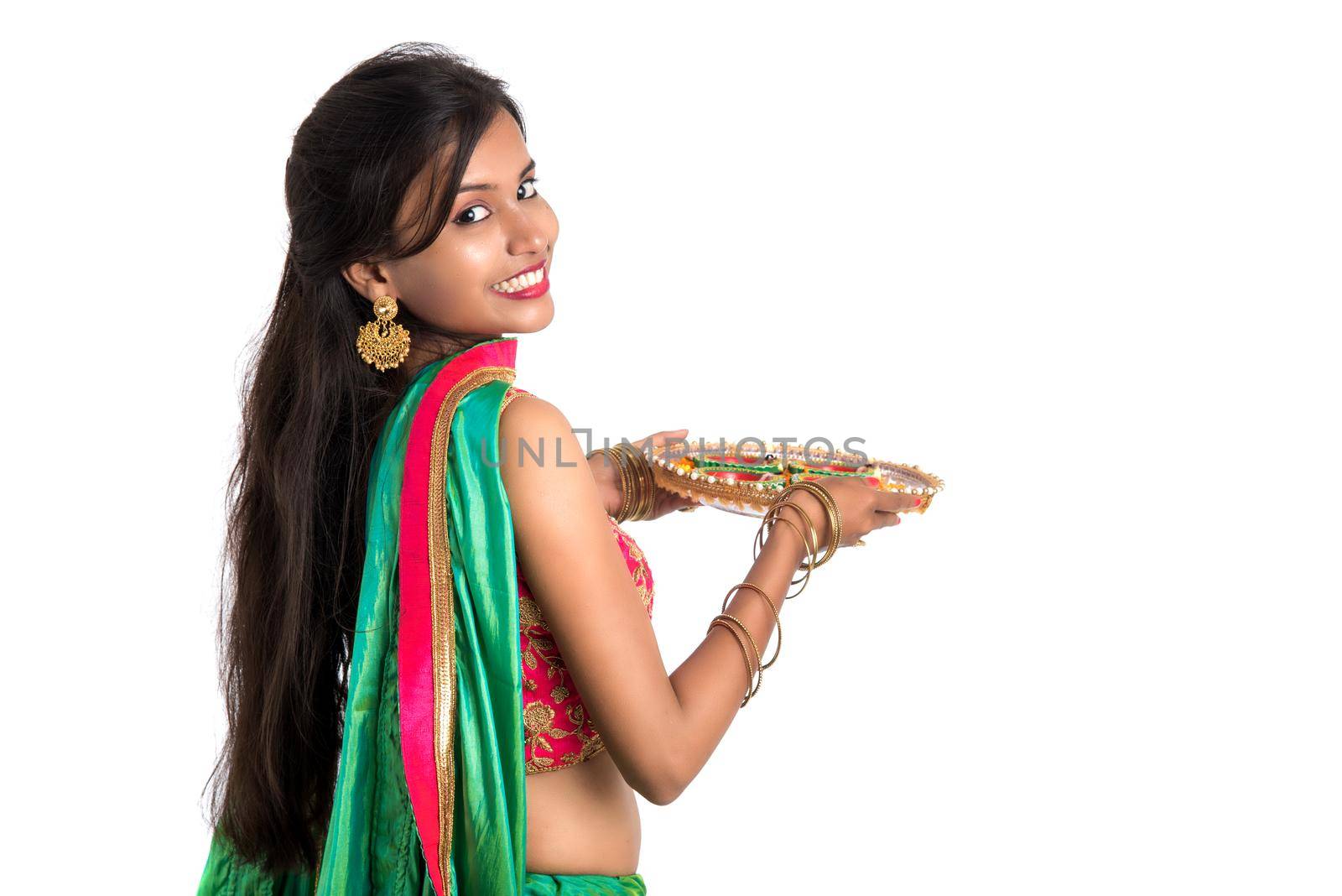 Portrait of a Indian Traditional Girl holding Diya, Girl Celebrating Diwali or Deepavali with holding oil lamp during festival of light on white background
