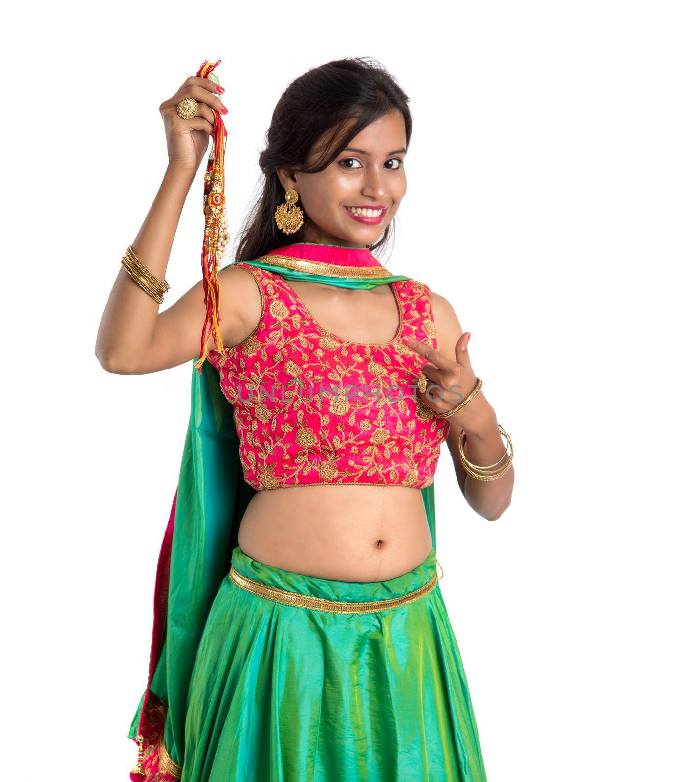 Beautiful girl showing Rakhi on occasion of Raksha bandhan on a white background. Sister tie Rakhi as symbol of intense love for her brother.