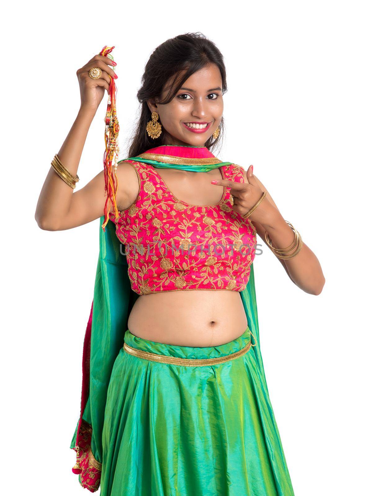 Beautiful girl showing Rakhi on occasion of Raksha bandhan on a white background. Sister tie Rakhi as symbol of intense love for her brother.