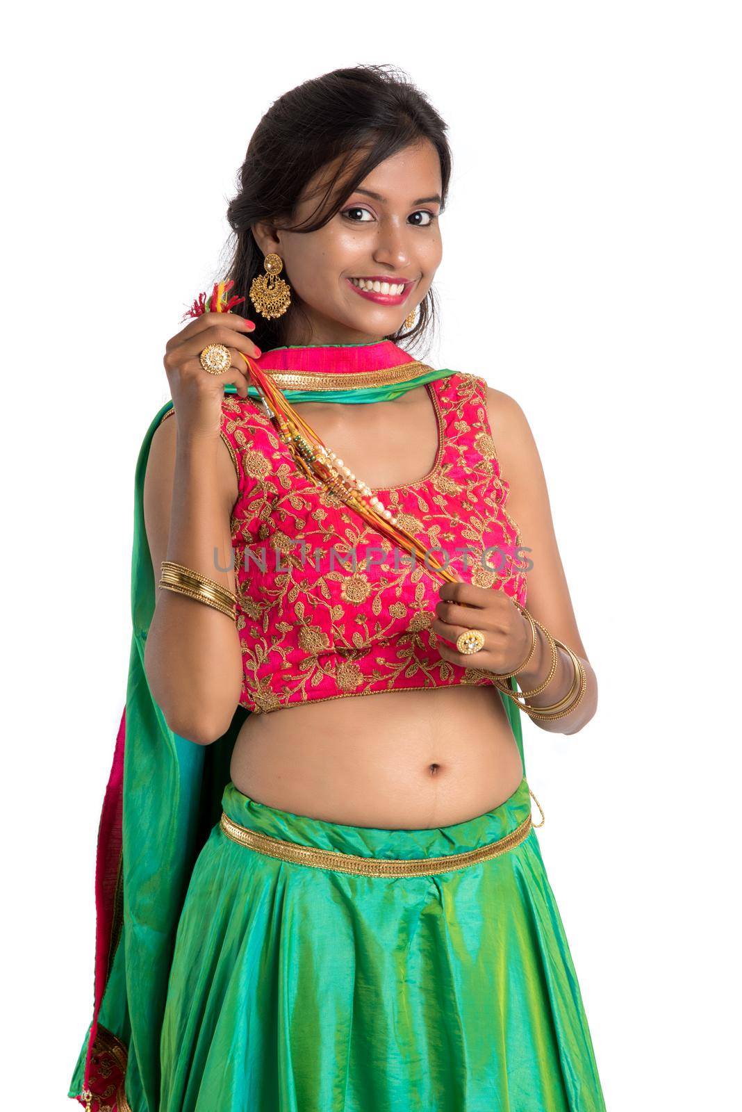 Beautiful girl showing Rakhi on occasion of Raksha bandhan on a white background. Sister tie Rakhi as symbol of intense love for her brother.