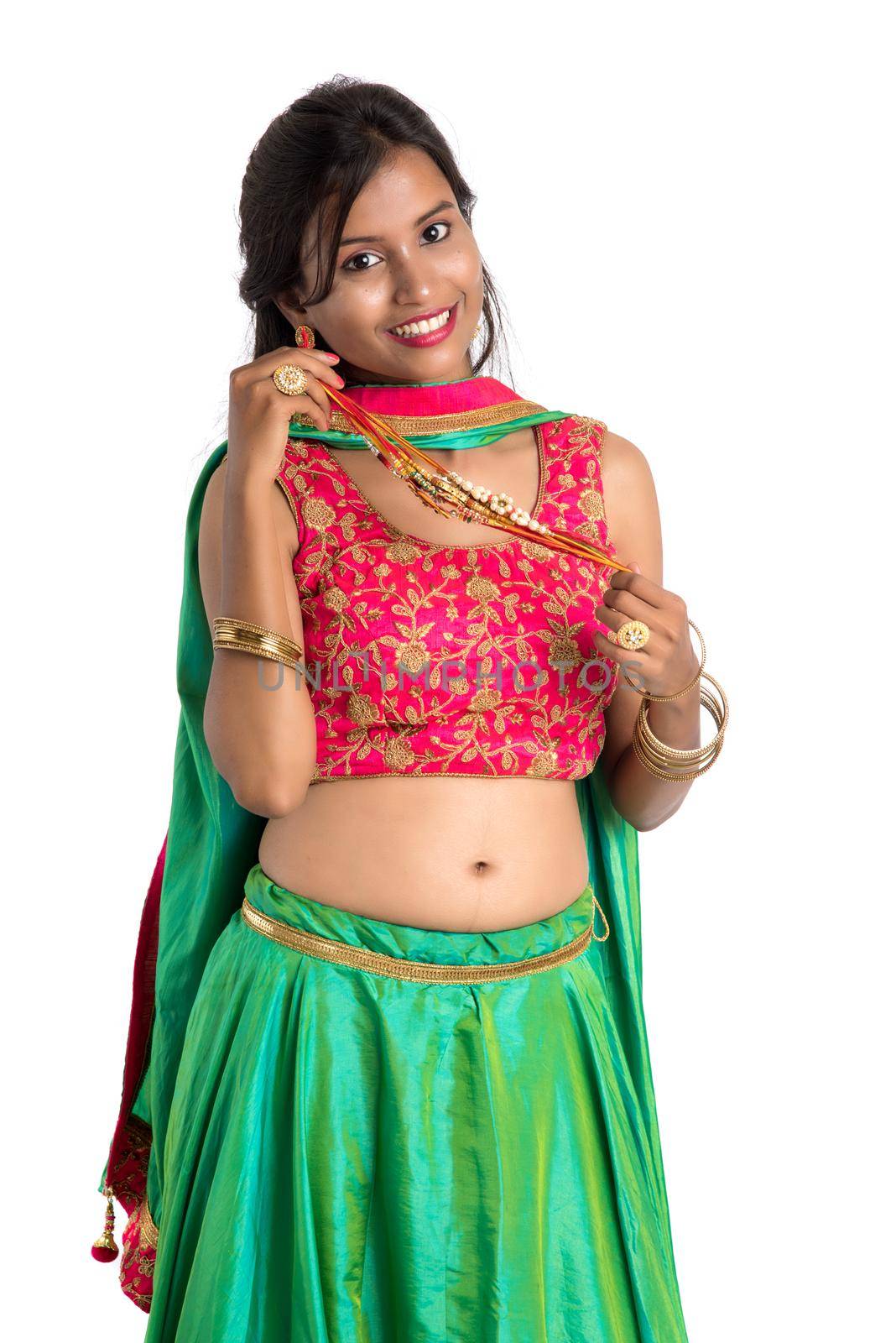 Beautiful girl showing Rakhi on occasion of Raksha bandhan on a white background. Sister tie Rakhi as symbol of intense love for her brother.