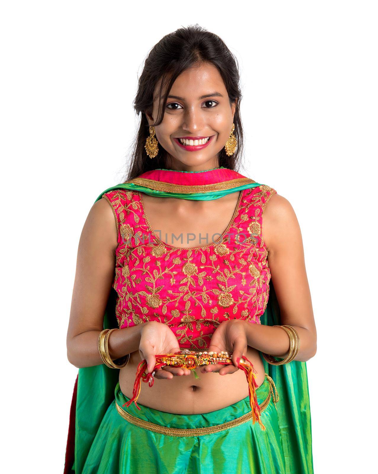 Beautiful girl showing Rakhi on occasion of Raksha bandhan on a white background. Sister tie Rakhi as symbol of intense love for her brother.