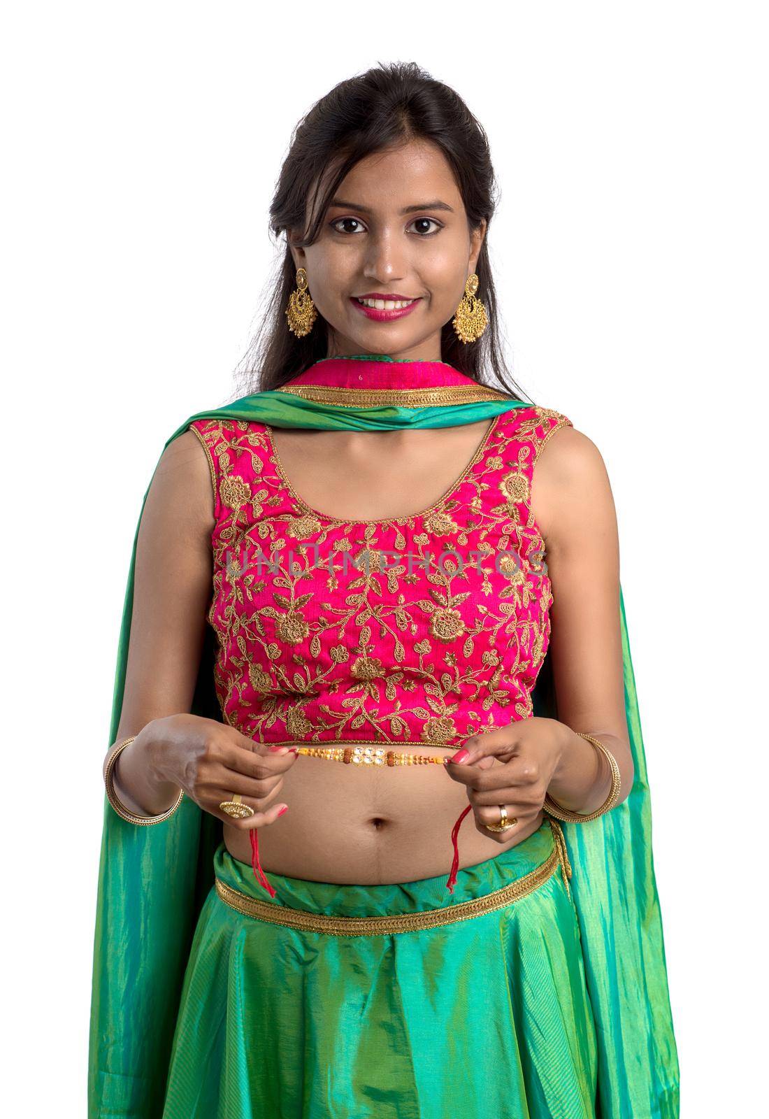 Beautiful girl showing Rakhi on occasion of Raksha bandhan on a white background. Sister tie Rakhi as symbol of intense love for her brother.