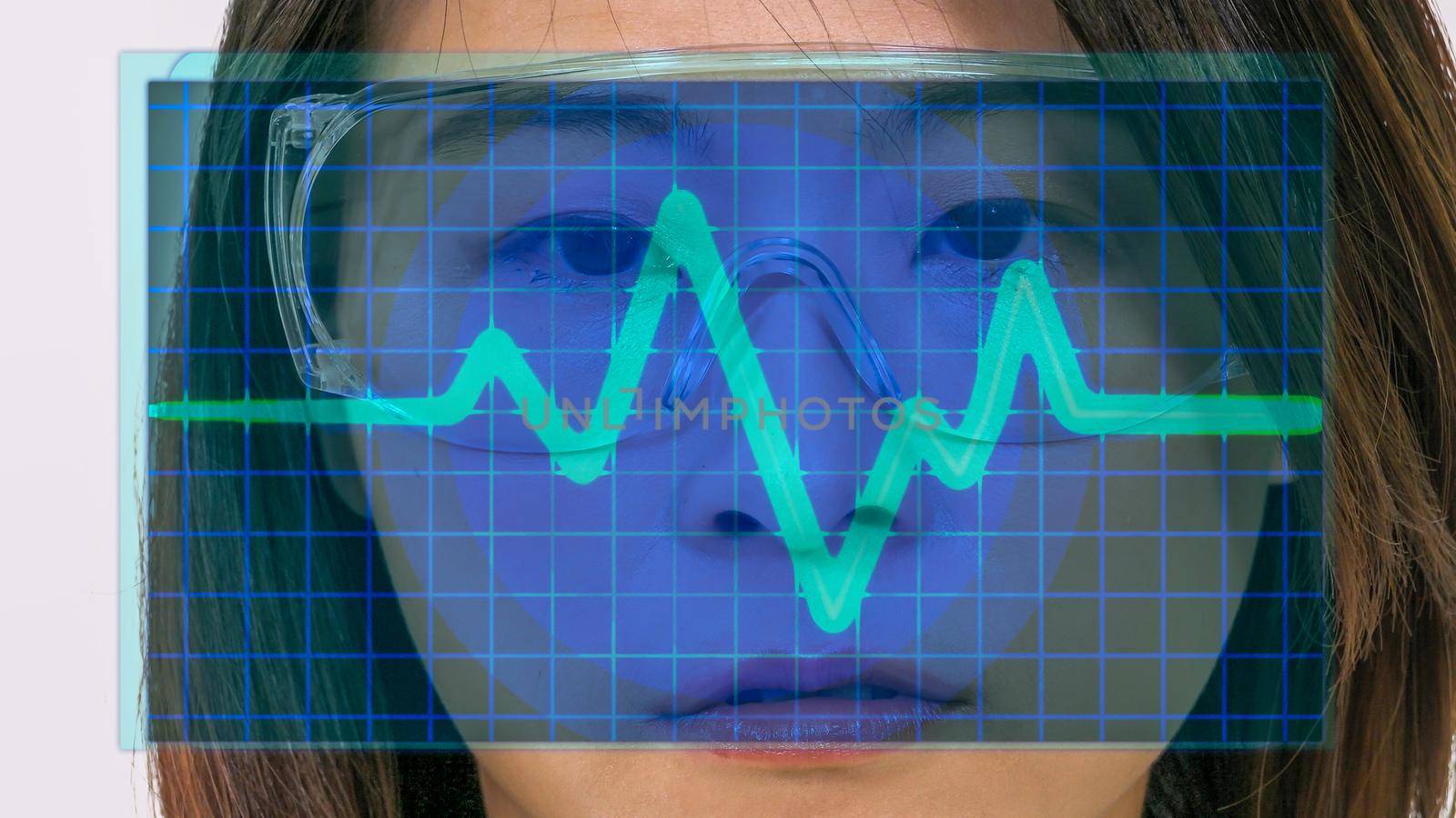 Female Asian doctor looks at virtual medical EKG screen by imagesbykenny