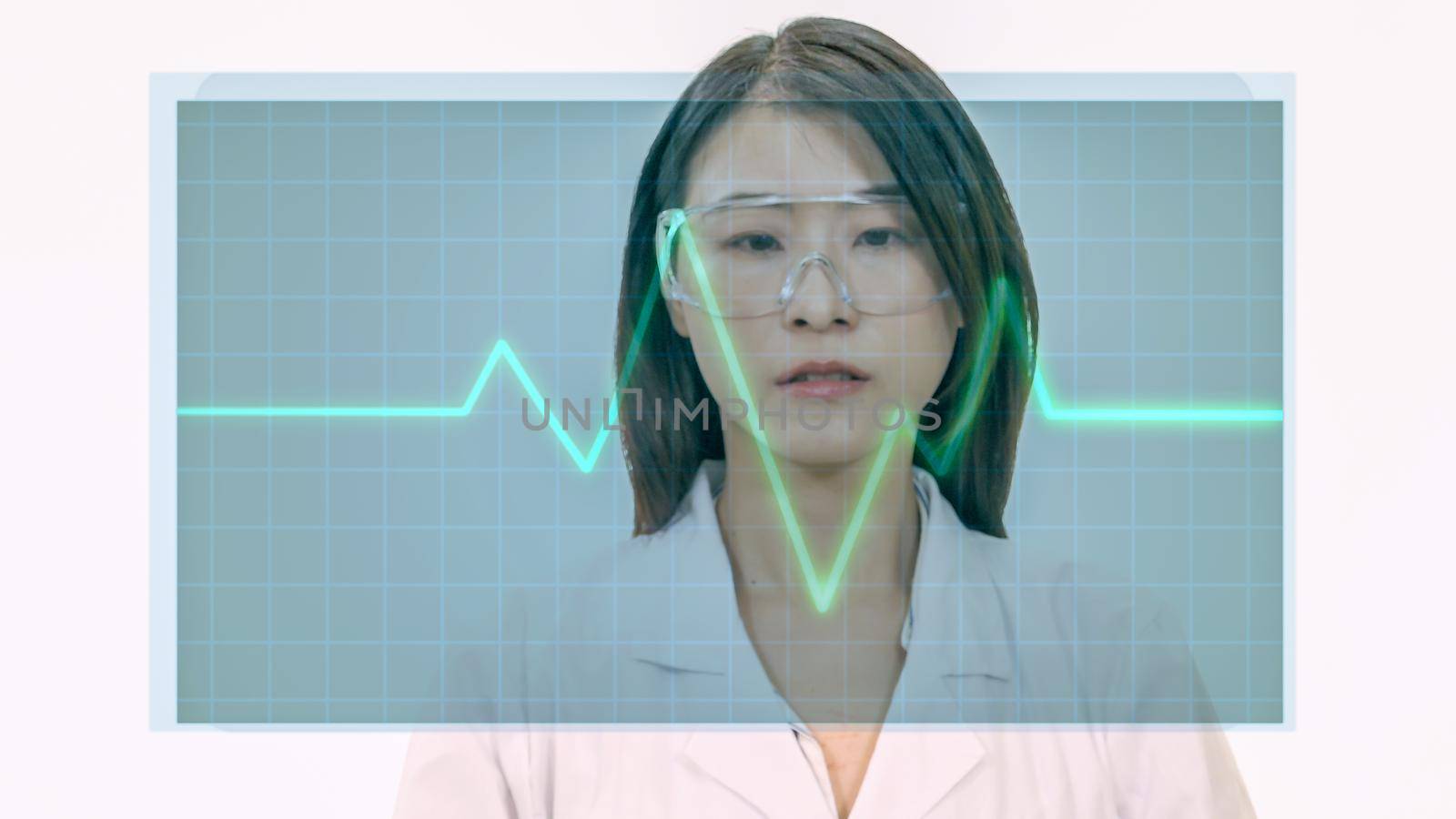 Female Asian doctor looks at virtual medical EKG screen by imagesbykenny