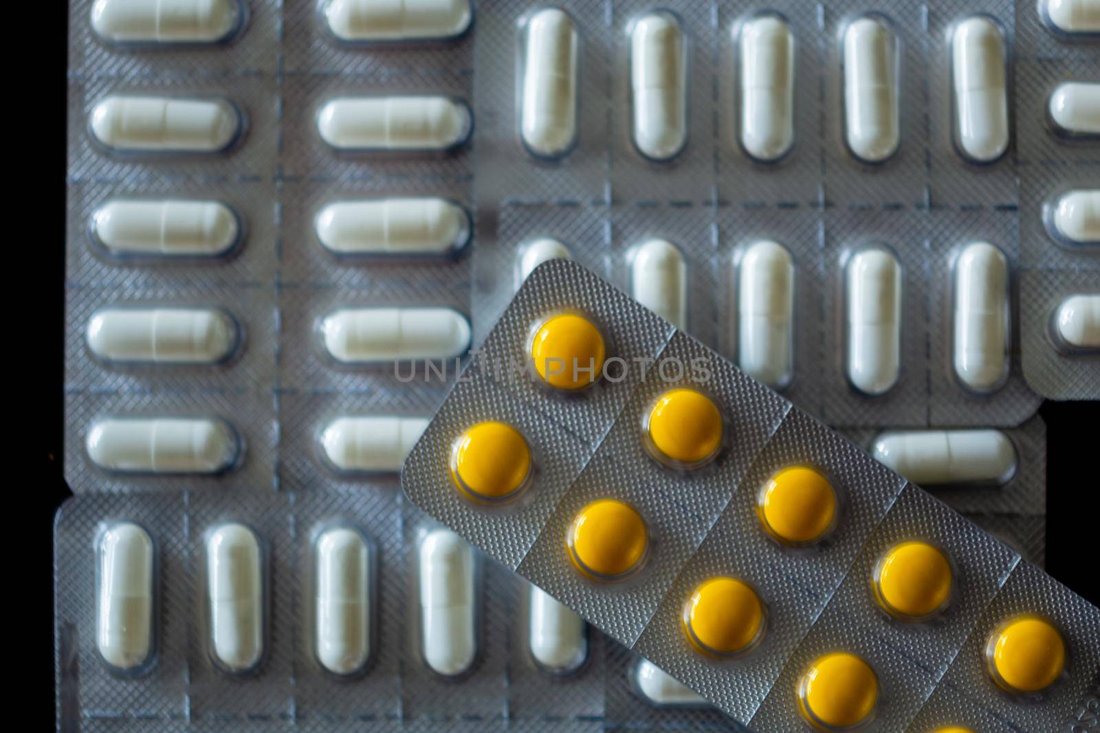 Flat lay shot of tablets in blister pack on black background