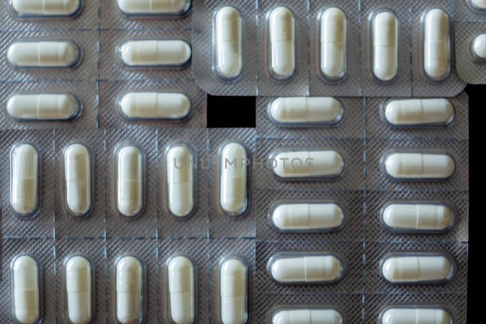 Flat lay shot of tablets in blister pack on black background