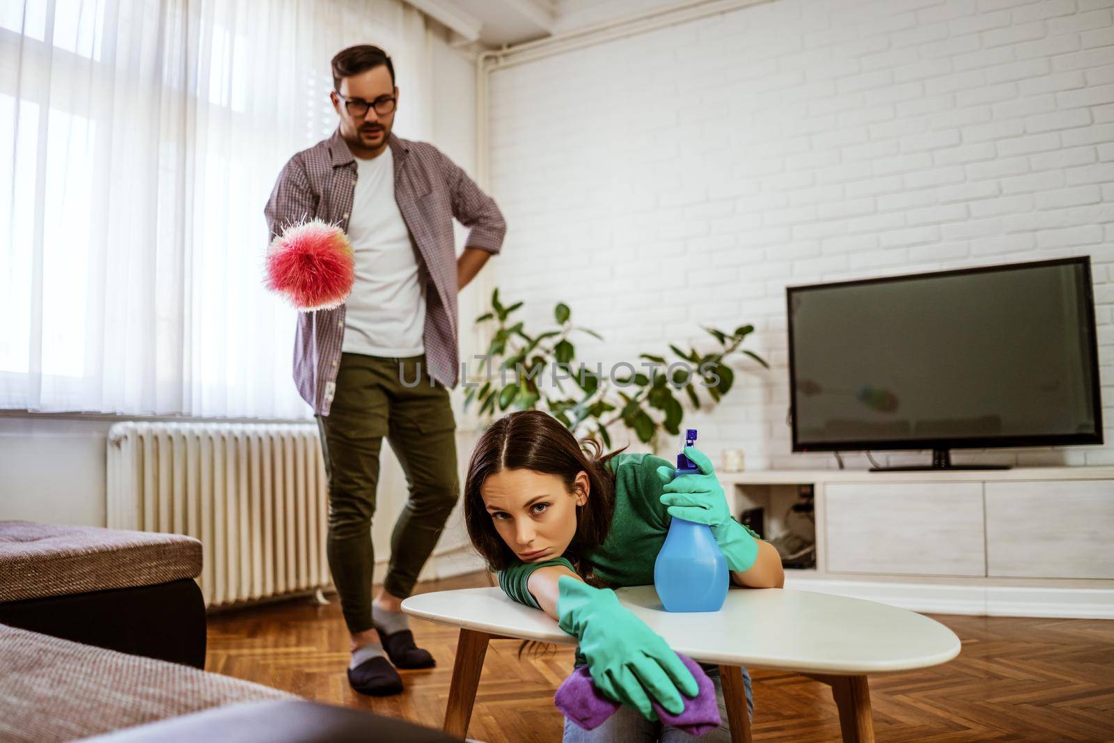 Lazy woman is refusing to clean the apartment. Man is angry.