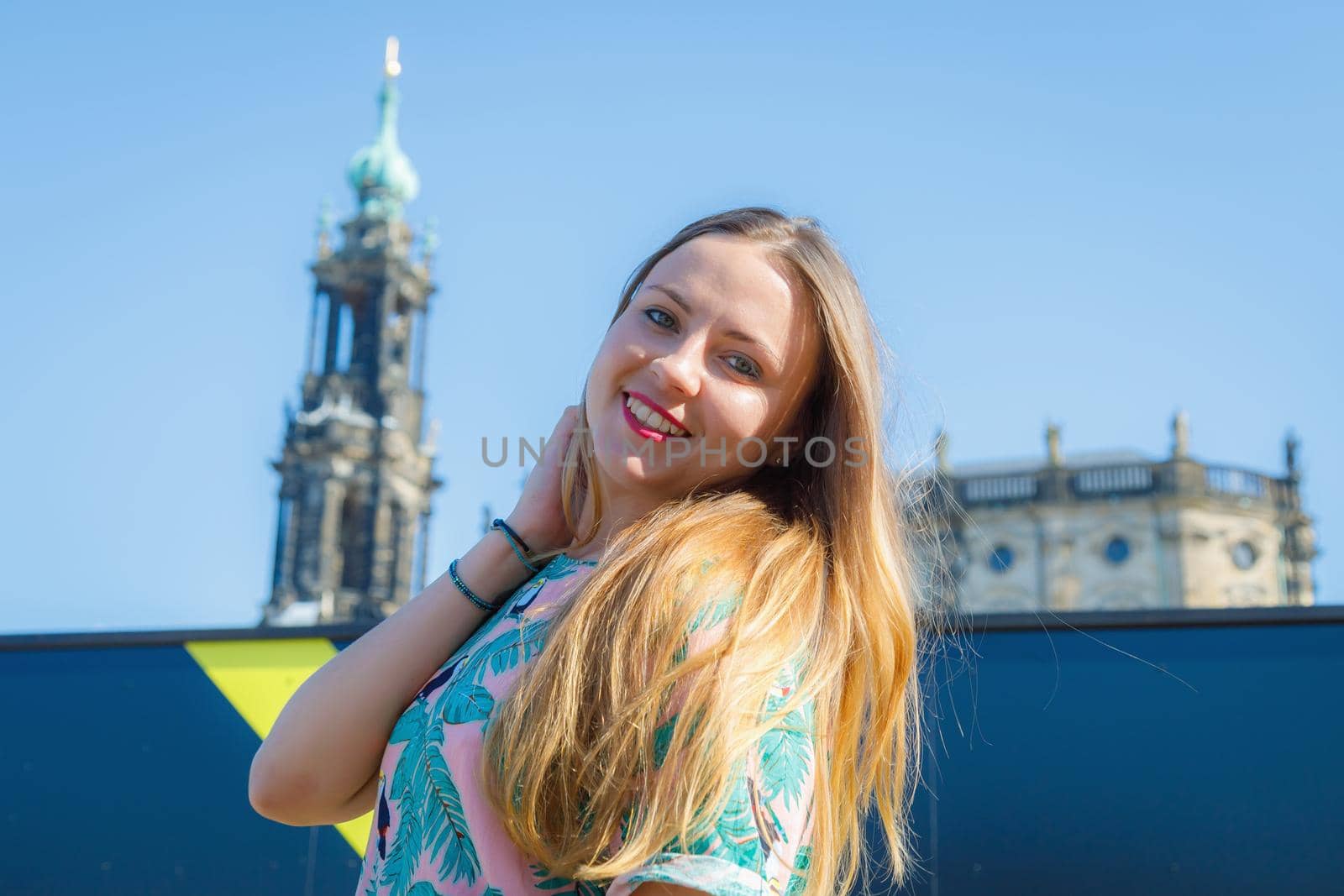 A young beautiful girl walks around the city on excursions. Cheerful, happy laugh.