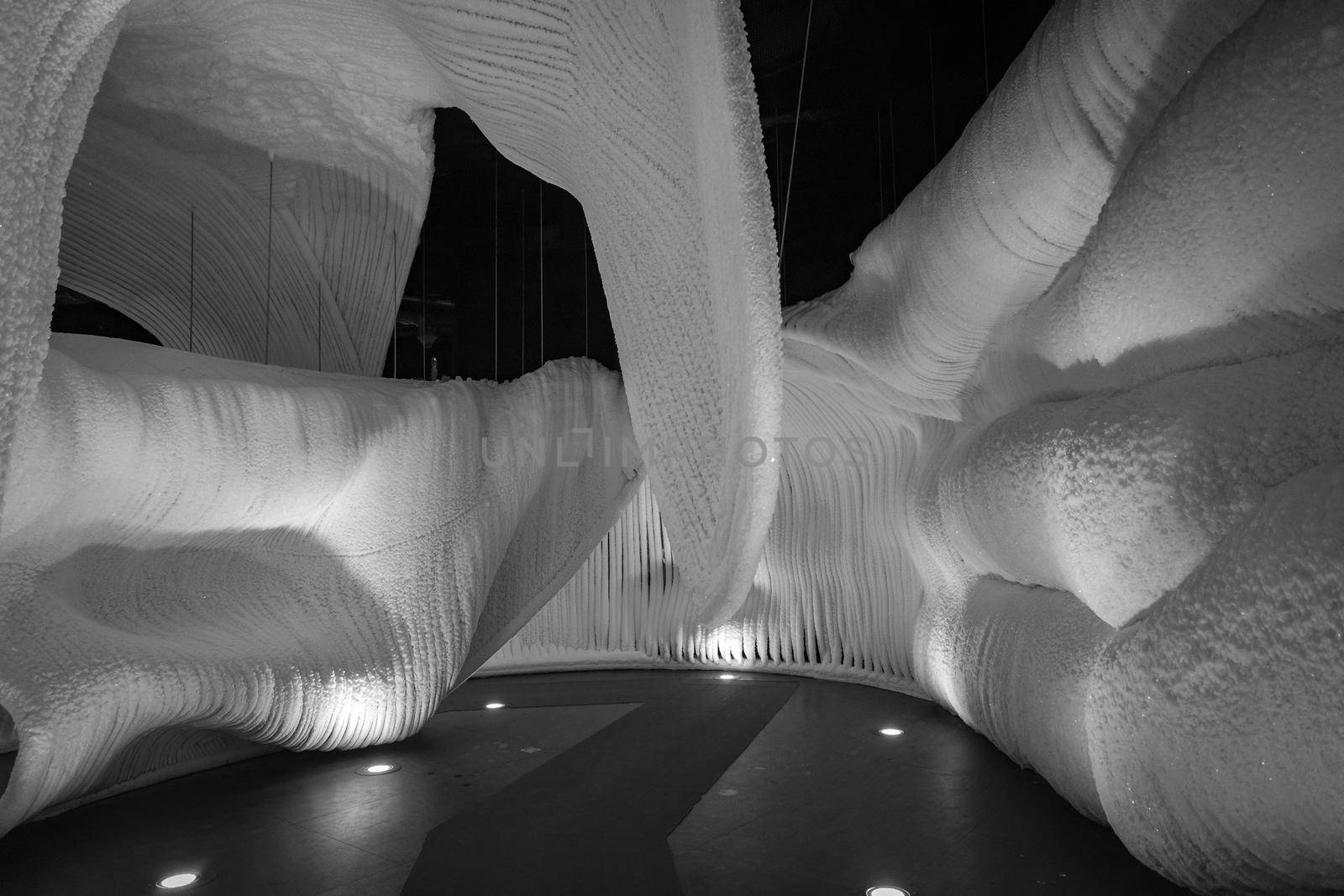 A fabulous artificial ice cave, the walls are covered with snow and illuminated. Frozen ice and cold inside