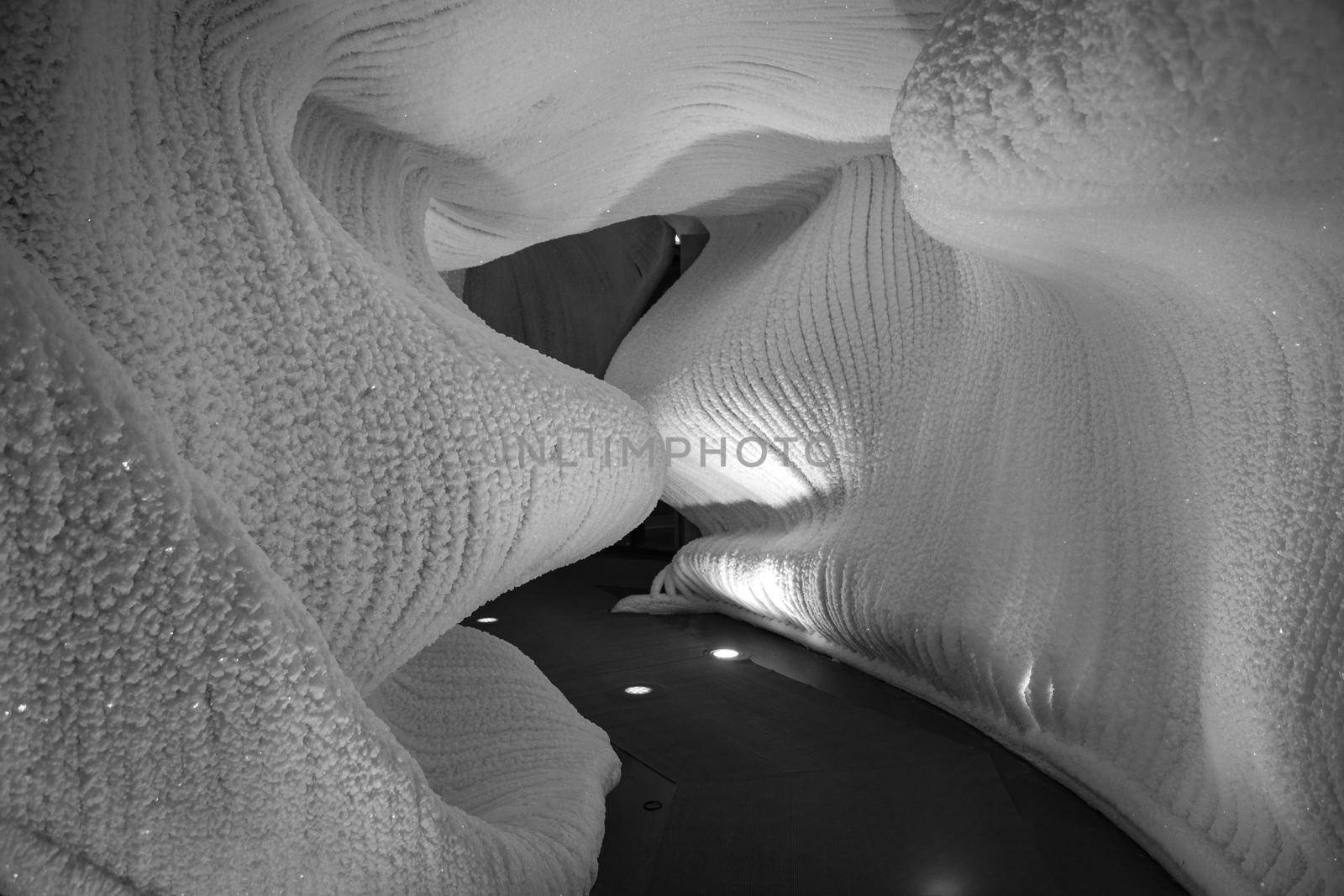 A fabulous artificial ice cave, the walls are covered with snow and illuminated. Frozen ice and cold inside